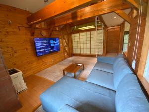 a living room with a blue couch and a tv at Annupuri Retro Lodge in Niseko +6 photos