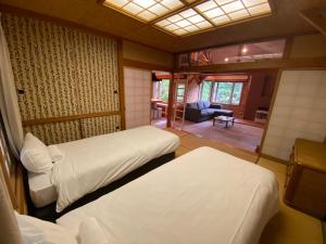 a bedroom with two beds and a living room at Annupuri Retro Lodge in Niseko