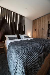 a bedroom with a large bed with a wooden headboard at Soba za noćenje Tončica in Požega