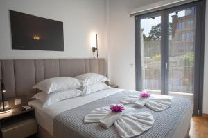 een slaapkamer met een bed met handdoeken erop bij Aonia Luxurious Modern Boutique Apartments in Chalkida