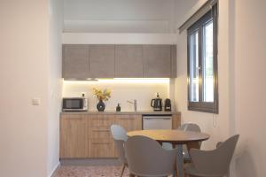 a kitchen with a table and chairs and a microwave at Aonia Luxurious Modern Boutique Apartments in Chalkida