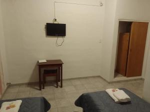 Zimmer mit einem Bett, einem Tisch und einem TV in der Unterkunft Hotel Hualum in Villa Dolores