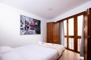 een slaapkamer met 2 bedden en een groot raam bij Apartamentos Turísticos Distrito Romano in Cartagena