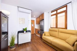 een woonkamer met een bank en een keuken bij Apartamentos Turísticos Distrito Romano in Cartagena