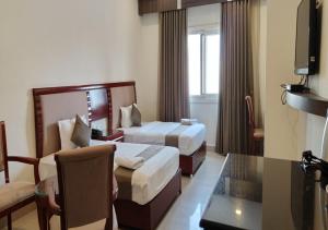 HOTEL REDLAS INN في Sangāreddi: غرفة فندقية بسريرين وطاولة