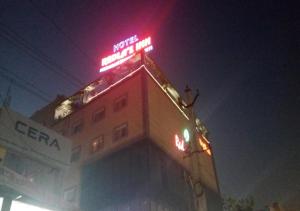 Un bâtiment avec un panneau de néon en haut. dans l'établissement HOTEL REDLAS INN, à Sangāreddi