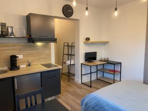 a room with a kitchen with a bed and a desk at Au 3 rue Manhès in Albi