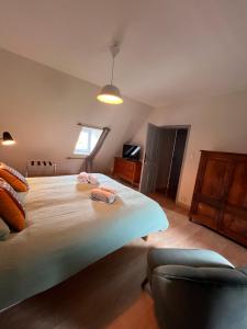 a bedroom with a large bed with two towels on it at Maison d'hôtes de la prison en toutes libertés in Espalion