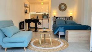 a living room with two beds and a blue couch at Le bohème in La Houssaye-en-Brie