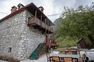 a building with tables and chairs and a balcony at Kulla Pracja Theth in Theth