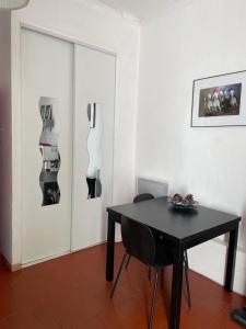 einen schwarzen Tisch und Stühle in einem Zimmer mit Tür in der Unterkunft Studio pour 2 personnes in Arles
