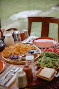 a table topped with plates of food and vegetables at Kulla Pracja Theth in Theth +63 photos