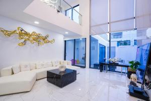 una sala de estar con un sofá y una mesa en Your Days pool villa, en Pattaya South