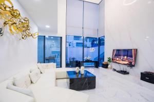 Una sala de estar con un sofá blanco y un televisor. en Your Days pool villa, en Pattaya South