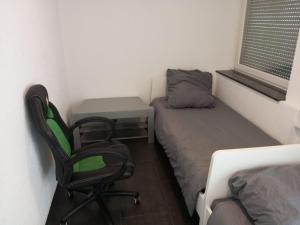 Mały pokój z łóżkiem, biurkiem i krzesłem w obiekcie Eve Zimmer in Heilbronn Zentrum w mieście Heilbronn