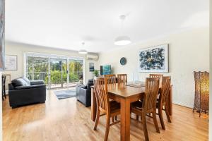 ein Esszimmer und ein Wohnzimmer mit Tisch und Stühlen in der Unterkunft 1-3A Montague Street, Narooma in Narooma + 11 Fotos