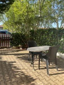 a picnic table and two chairs on a patio at Studio Climatisé pour 2 pers - Salins de Giraud in Salin-de-Giraud +5 photos