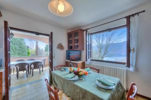 a dining room with a table and a large window at Casa Serena park and Lake View - Happy Rentals in Pettenasco