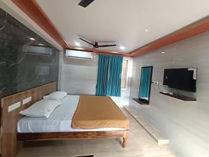 a bedroom with a bed and a flat screen tv at SDD Grand in Tiruvannāmalai