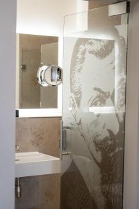 a glass shower door with a picture of a man at Maxim Suites by Elias Holl in Augsburg