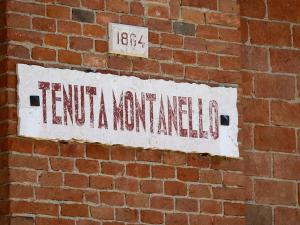 een bord aan de zijkant van een stenen muur bij Tenuta Montanello B&B in Castiglione Falletto