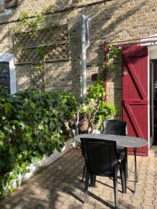 a table and chairs in front of a building with a red door at Studio Climatisé pour 2 pers - Salins de Giraud in Salin-de-Giraud