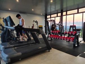 a man on a treadmill in a gym at Comodo Apartemen Pollux Habibie Rooftop-SeaView in Batam Center