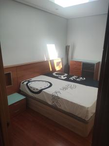 1 dormitorio con 1 cama con edredón blanco y negro en Alquiler apartamento 1 linea de playa en Suances