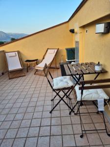 eine Terrasse mit einem Tisch und Stühlen auf dem Dach in der Unterkunft La Mansarda Di Cecco in Avezzano