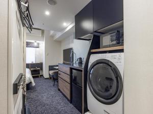 a laundry room with a washer and a desk at Tokyu Stay Nishi Shinjuku in Tokyo