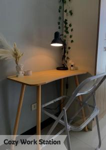 una scrivania in legno con lampada e sedia di LK Staycation a Imus