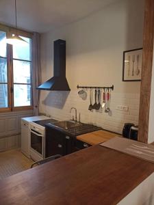 une cuisine avec un évier et une cuisinière four supérieur dans l'établissement Ty Salang - Appartement Cosy et Calme - Centre Historique Rennes, à Rennes