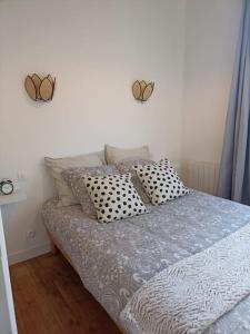 - un lit dans une chambre avec deux cœurs sur le mur dans l'établissement Ty Salang - Appartement Cosy et Calme - Centre Historique Rennes, à Rennes 12 autres photos