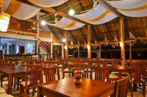 an empty restaurant with wooden tables and chairs at Punta Bulata White Beach Resort & Spa in Sipalay