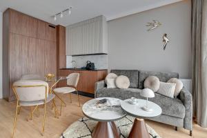 ein Wohnzimmer mit einem Sofa und einem Tisch in der Unterkunft Downtown Apartments Riverside Nadmotławie Estate - Gym & Sauna in Danzig