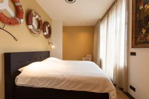 ein Schlafzimmer mit einem weißen Bett und einem Fenster in der Unterkunft Appartement Globo in Middelburg