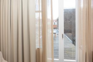 eine Glasschiebetür mit Blick auf einen Balkon in der Unterkunft Appartement Globo in Middelburg