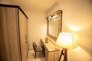 a room with a desk with a mirror and a lamp at Sueen Nature Resort in Hatton