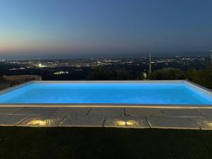 - une piscine bleue avec vue sur la ville dans l'établissement Trulli Belvedere di Puglia, à Selva di Fasano