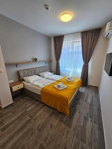 a bedroom with a bed with a yellow blanket on it at Villa Kotlar in Ohrid