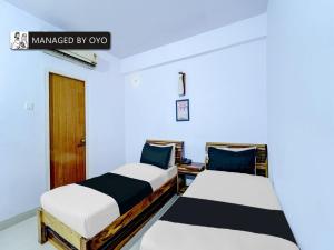 two beds in a room with blue and white at Collection O Rajendra Path Near Patna Junction Railway Station - Managed by Company in Patna
