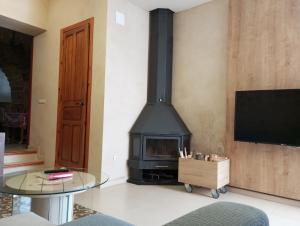 a fireplace in a living room with a table and a tv at Casa rural Puchero y Manta in Alcudia de Veo
