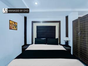a bedroom with a large bed with a black headboard at Collection O Rajendra Path Near Patna Junction Railway Station - Managed by Company in Patna