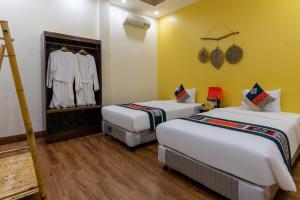2 Betten in einem Zimmer mit gelben Wänden in der Unterkunft Sapa Heaven House in Sa Pả