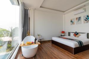 Schlafzimmer mit einem Bett, einer Badewanne und einem Fenster in der Unterkunft Sapa Heaven House in Sa Pả