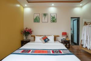 ein Schlafzimmer mit einem Bett und Blumen an der Wand in der Unterkunft Sapa Heaven House in Sa Pả