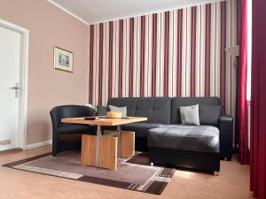 - un salon avec un canapé et une table dans l'établissement Apartmenthaus Gutenberg 78, à Potsdam