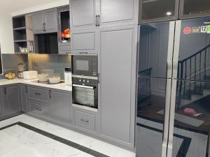 a kitchen with white cabinets and a microwave at LaLa Penthouse in Hue