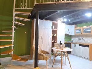 a loft bed in a kitchen with a table and chairs at Gallery apartment in Podgorica