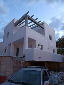 una casa en construcción con un coche aparcado delante en Nueva Casa Alhamar en Punta Umbría